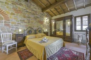 a bedroom with a bed and a stone wall at Villa di Capannole 12 in Bucine +34 photos