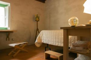a bedroom with a bed and a table and a lamp at BORGO PETELIA, Casa Centro, Antica abitazione calabrese con giardino, ristrutturata in Strongoli