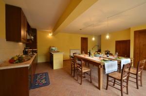 una cucina con un grande tavolo in legno e sedie di Casa Minuccia a Castelnuovo Berardenga