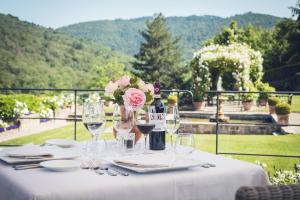 a table with wine glasses and a bottle of wine at Capannelle Wine Resort in Gaiole in Chianti