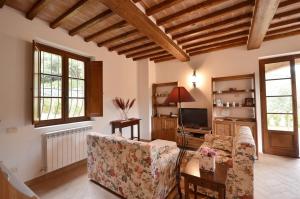 Una sala de estar con un sofá y un televisor. en Casa Maria, en Castelnuovo Berardenga