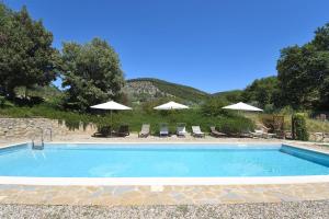 una gran piscina con sillas y sombrillas en Casa Maria, en Castelnuovo Berardenga