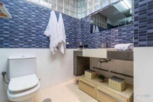 Lujo a tu alcance con spa y garaje pleno centro في هويلفا: حمام مع مرحاض ومغسلة ومرآة
