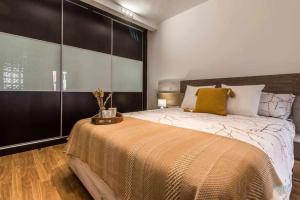 1 dormitorio con 1 cama grande con almohadas amarillas en Lujo a tu alcance con spa y garaje pleno centro en Huelva