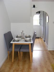 a dining room table with blue chairs and a white table at Demesnes View in Barnard Castle