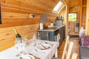a dining room with a table and a kitchen at BenVrackie Luxury Glamping Pet Friendly Pod at Pitilie Pods in Aberfeldy +12 photos