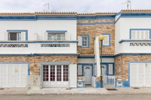 un edificio con puertas azules y blancas y una calle en 4 bedroom villa wi-fi and shared pool by ALGARVEMANTA, en Manta Rota