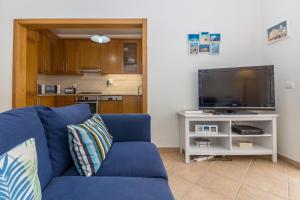 sala de estar con sofá azul y TV en 4 bedroom villa wi-fi and shared pool by ALGARVEMANTA, en Manta Rota