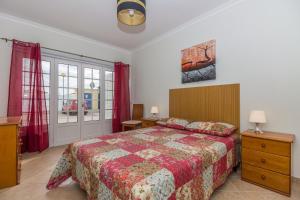a bedroom with a bed with a red comforter at 4 bedroom villa wi-fi and shared pool by ALGARVEMANTA in Manta Rota