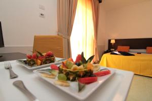 dos platos de fruta en una mesa en una habitación en Club Esse Sunbeach, en Squillace