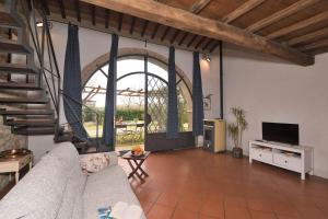 sala de estar con sofá y ventana grande en Limonaia, en Sovicille