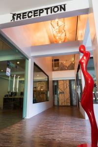 a red sculpture in front of a store at OneLoft Hotel - SHA Plus in Karon Beach