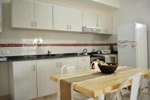 eine Küche mit einem Holztisch und einem weißen Kühlschrank in der Unterkunft DEPTO KENIA. ALQUILER TEMPORARIO EN SAN FRANCISCO in San Francisco + 10 Fotos