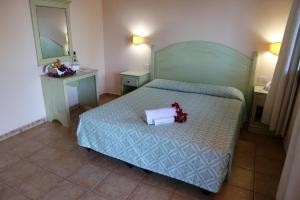 a hotel room with a bed and a dresser at Club Esse Cala Gonone in Cala Gonone