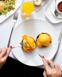 a person holding a fork over a plate of food at Four Seasons Hotel Moscow in Moscow