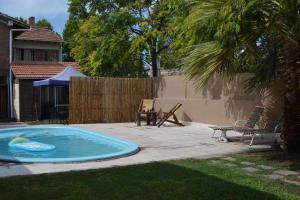 una piscina en un patio con una mesa y una valla en Open House Hostel en Mendoza