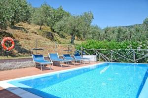 una piscina con sillas azules y una piscina en Oleandro, en Calci