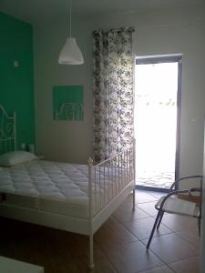 a bedroom with a bed and a large window at Dimitris House in Karistos