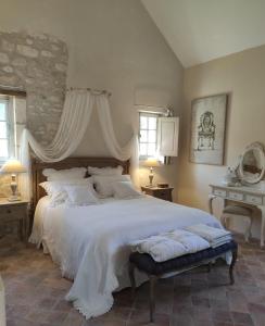 - une chambre avec un grand lit et des draps blancs dans l'établissement La Ferme Blanche, à Cussay