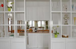a white kitchen with white cabinets and a mirror at Palazzo Ca'nova on the Grand Canal - Canella Apartment in Venice