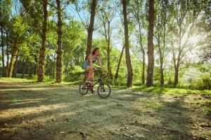 a woman riding a bike down a dirt road at Agriturismo Lunadoro in Monticchiello