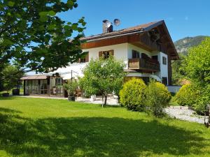 ein Haus mit grünem Rasen davor in der Unterkunft Kaiser's Landhaus in Schliersee