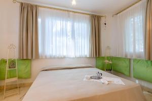 um quarto com uma cama grande com toques de verde em Iris em Castagneto Carducci