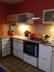 uma cozinha com armários brancos e um forno com placa de fogão em Les Trois Rois em Nîmes