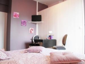 een slaapkamer met een bed met roze muren en een bureau bij Maunoury Citybreak in Chartres