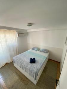 Un dormitorio con una cama con un par de zapatos. en Scala Residence, en Fortaleza