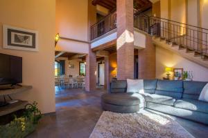 Una sala de estar con un sofá azul y una escalera. en Villa Lestra, en Peccioli