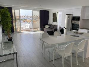una cucina e un soggiorno con tavolo e sedie di Jandia Suite a Morro del Jable