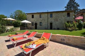 a patio with two chairs and a table with a blanket at La Rana in Gaiole in Chianti