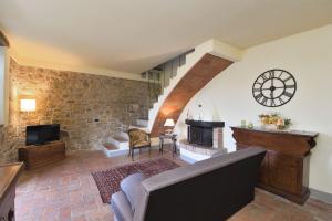 a living room with a clock on the wall at La Rana in Gaiole in Chianti