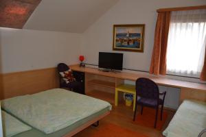 Cette chambre comprend un bureau avec un ordinateur et deux chaises. dans l'établissement Hotel Hessengüetli, à Winterthour