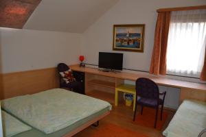 a room with a desk with a computer and two chairs at Hotel Hessengüetli in Winterthur