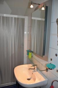 
a white sink sitting under a mirror in a bathroom at Hotel Hessengüetli in Winterthur
