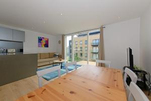 een eetkamer en een woonkamer met een houten tafel bij Executive Apartment Near Chiswick and Kew Gardens in Chiswick