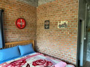 a brick wall with a bed in a room at PilokMyhome ที่พักเหมืองปิล็อก บ้านอีต่อง in Ban Pilok Khi