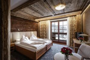 a bedroom with a bed and a desk and a window at Alpejski Boutique Hotel in Karpacz