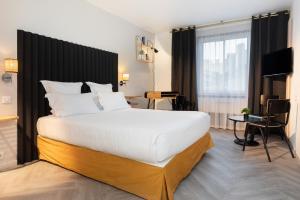 リヨンにあるHôtel Chromatics & Restaurant Hill Club by HappyCultureの大きなベッドとデスクが備わるホテルルームです。