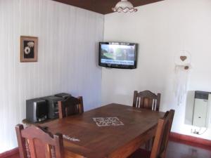 a dining room table with a television on the wall at Cerro Chico Brochero in Villa Cura Brochero