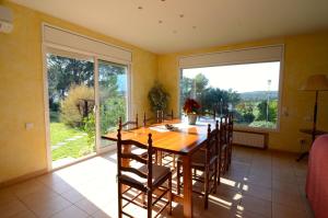 une salle à manger avec une table, des chaises et une grande fenêtre dans l'établissement Villa La Romaguera, à Garrigolas