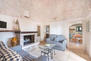 a living room with two chairs and a fireplace at Trullo Amare in Monopoli