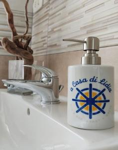 un dispensador de jabón sentado en la parte superior de un lavabo en A Casa di Lidia B&B Gaeta, en Gaeta