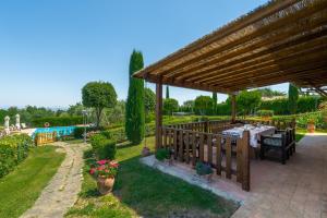 a wooden pavilion with a table and a pool at Agriturismo I Colli in Montaione