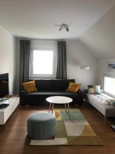 a living room with a black couch and a table at Apartment Green Paradise in Moravske-Toplice