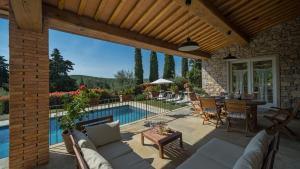 patio z basenem, stołem i krzesłami w obiekcie La Casa di Radda w mieście Radda in Chianti