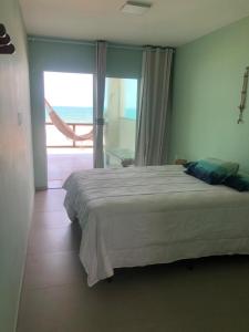 1 dormitorio con 1 cama y vistas al océano en Tabubinha Paradise en Beberibe