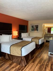 2 camas en una habitación de hotel con suelo de madera en Country Hearth Inn & Suites Cartersville, en Cartersville